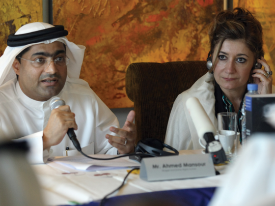 A man in an Arabian traditional dress and a woman having a press conference.