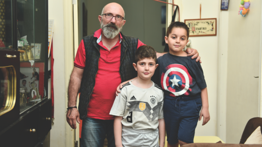 Boyadjian in his Bourj Hammoud apartment with his two sons David (left) and Daniel (right).